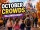 Disneyland Paris October crowds guide showing autumn park with Halloween decorations, pumpkins and moderate to busy crowds walking toward castle